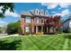 Beautiful brick home featuring a lush front lawn, mature trees, and classic architectural details at 12122 Camden Trail Ct, Charlotte, NC 28277
