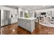 Open kitchen with island seating area flows into the main living space; stainless refrigerator at 12122 Camden Trail Ct, Charlotte, NC 28277