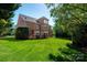 Expansive backyard with a brick home featuring multiple decks and lush greenery, offering outdoor enjoyment at 12122 Camden Trail Ct, Charlotte, NC 28277