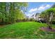 Large backyard space showcasing green grass and mature trees along the property's edge at 13505 Michael Lynn Rd, Charlotte, NC 28278