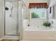 Clean bathroom with a glass-door shower, bathtub, and a window with outside view at 13505 Michael Lynn Rd, Charlotte, NC 28278