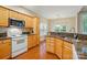 Bright kitchen featuring granite countertops, wooden cabinetry, and stainless steel appliances at 13505 Michael Lynn Rd, Charlotte, NC 28278