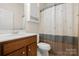 Bathroom with warm-toned cabinets, neutral walls, and a shower-tub with decorative curtain at 1488 River Bend Blvd, Fort Mill, SC 29707