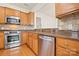 Modern kitchen featuring stainless steel appliances, granite countertops, and wooden cabinetry at 1488 River Bend Blvd, Fort Mill, SC 29707