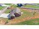 Aerial view of home with brown siding, three-car garage, and a long driveway at 164 Castle Pines Ln, Statesville, NC 28625