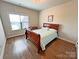 Bright bedroom with hardwood floors, a large window, and a cozy bed with decorative pillows at 164 Castle Pines Ln, Statesville, NC 28625