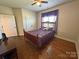 Cozy bedroom with hardwood floors, a large window, and a comfortable bed with purple linens at 164 Castle Pines Ln, Statesville, NC 28625