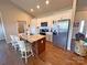 Bright kitchen boasts white cabinets, stainless steel appliances, island with seating, and hardwood floors for style and function at 164 Castle Pines Ln, Statesville, NC 28625