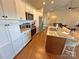 Bright kitchen with white cabinets, stainless steel appliances, a central island, and hardwood floors at 164 Castle Pines Ln, Statesville, NC 28625