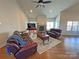 Inviting living room featuring a stone fireplace, hardwood floors, vaulted ceilings, and comfortable seating for relaxation at 164 Castle Pines Ln, Statesville, NC 28625