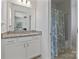 Bright bathroom with granite counters, white vanity, large mirror and a shower and tub with a patterned curtain at 184 Tetcott St, Mooresville, NC 28115