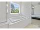 Relax in this soaking tub situated beneath a window in this bright main bathroom at 184 Tetcott St, Mooresville, NC 28115