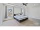 Bright primary bedroom features tray ceiling, carpet, large windows, and ensuite bathroom at 184 Tetcott St, Mooresville, NC 28115