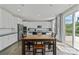 Bright kitchen with white cabinets, stainless steel appliances, a dining area, and sliding glass doors to the backyard at 184 Tetcott St, Mooresville, NC 28115