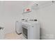 Bright laundry room with tile floor, modern washer and dryer and wire storage shelf at 184 Tetcott St, Mooresville, NC 28115