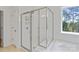 This modern shower features a glass door, tiled walls, and backyard views at 184 Tetcott St, Mooresville, NC 28115