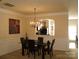 Elegant dining room with modern chandelier, a glass table, and adjacent kitchen view at 1960 Aston Mill Pl, Charlotte, NC 28273