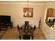Elegant dining room with modern chandelier, a glass table, and adjacent kitchen view at 1960 Aston Mill Pl, Charlotte, NC 28273