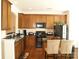 Well-lit kitchen with wooden cabinets, granite countertops, stainless appliances, and bar seating at 1960 Aston Mill Pl, Charlotte, NC 28273