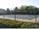 Community pool fenced in for safety features tall shrubbery and a partially covered pool at 1960 Aston Mill Pl, Charlotte, NC 28273
