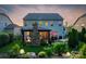 Backyard view of a two-story home with a cozy covered patio, stone fireplace, and outdoor seating at 2002 Thurston Dr, Indian Trail, NC 28079