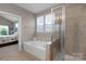 Relaxing bathroom featuring a soaking tub, a separate glass-enclosed shower, and natural light at 2002 Thurston Dr, Indian Trail, NC 28079