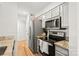 Kitchen with stainless steel appliances, gray cabinets, granite countertops, and hardwood floors at 212 W 10Th St # 17, Charlotte, NC 28202