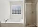 Bright bathroom features a soaking tub with a glass block window and a separate shower at 221 Sycamore Creek Rd, Fort Mill, SC 29708