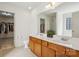 Bathroom with double sinks, wood cabinets, and a view to a shower and closet at 221 Sycamore Creek Rd, Fort Mill, SC 29708