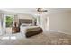 Bright bedroom featuring a large bed, neutral walls, and an open doorway to the bathroom at 221 Sycamore Creek Rd, Fort Mill, SC 29708