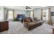 A spacious bedroom with a comfortable seating area, ceiling fan, and large windows at 221 Sycamore Creek Rd, Fort Mill, SC 29708