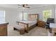 Bright bedroom with a upholstered bed frame, two windows, and a ceiling fan at 2340 Belterra Dr, Charlotte, NC 28216