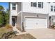 Close-up of the white garage door, gray siding, and front door of this inviting townhome at 2340 Belterra Dr, Charlotte, NC 28216