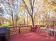 View of the backyard from the deck, featuring a table, umbrella, and mature trees at 237 Walnut Point Dr, Matthews, NC 28105