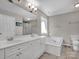 Bright bathroom with a double sink vanity, tub, window, and walk-in shower at 237 Walnut Point Dr, Matthews, NC 28105