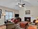 Cozy living room with a fireplace, ceiling fan, and large window for natural light at 237 Walnut Point Dr, Matthews, NC 28105