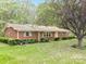 Charming red brick home with mature landscaping and a blooming tree in the front yard at 2582 Ivey Church Rd, Lincolnton, NC 28092