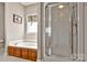 A well-lit bathroom featuring a garden tub with wood cabinets and a separate shower at 2610 Flagstone Ct, Shelby, NC 28152