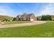 Sprawling brick home featuring an expansive driveway, lush lawn, and mature trees enhancing its curb appeal at 2610 Flagstone Ct, Shelby, NC 28152