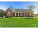 Charming brick home with a well-manicured lawn, rocking chairs on the front porch, and classic architectural details at 2610 Flagstone Ct, Shelby, NC 28152