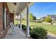 Inviting front porch with white columns, rocking chairs, and a scenic view of the landscaped front yard and neighborhood at 2610 Flagstone Ct, Shelby, NC 28152