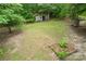 Large private backyard featuring mature trees, and shed providing ample storage for outdoor equipment and tools at 2929 Matoka Trl, Matthews, NC 28104