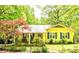 Charming yellow home featuring a covered porch with rocking chairs and beautifully landscaped front yard at 2929 Matoka Trl, Matthews, NC 28104