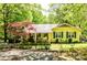 Quaint yellow house boasts inviting front porch and lush landscaping, perfect for Southern charm at 2929 Matoka Trl, Matthews, NC 28104