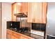 View of the kitchen features wood cabinets, stainless steel backsplash, black countertops, and a gas cooktop at 2929 Matoka Trl, Matthews, NC 28104