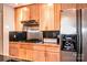 A well-equipped kitchen with wood cabinets, stainless steel appliances, and black countertops at 2929 Matoka Trl, Matthews, NC 28104
