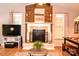 Hardwood floored living room showcasing a brick fireplace, bright windows, and a dining area at 2929 Matoka Trl, Matthews, NC 28104