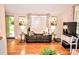 A cozy living room with hardwood floors, elegant curtains, and a comfortable couch for relaxing at 2929 Matoka Trl, Matthews, NC 28104