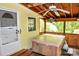 Inviting screened porch featuring a hot tub, wood floors, and cozy lighting at 2929 Matoka Trl, Matthews, NC 28104