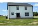 Back exterior featuring white siding, black trim, and slider leading to small deck at 3012 Isle Ln, Monroe, NC 28110